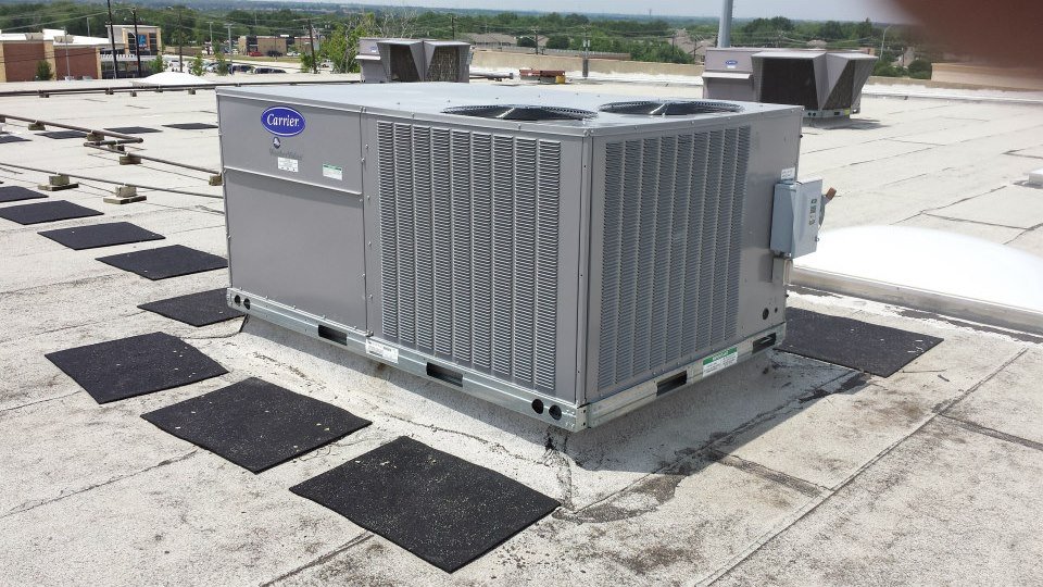 Carrier commercial rooftop air conditioning package unit installed on a flat building roof