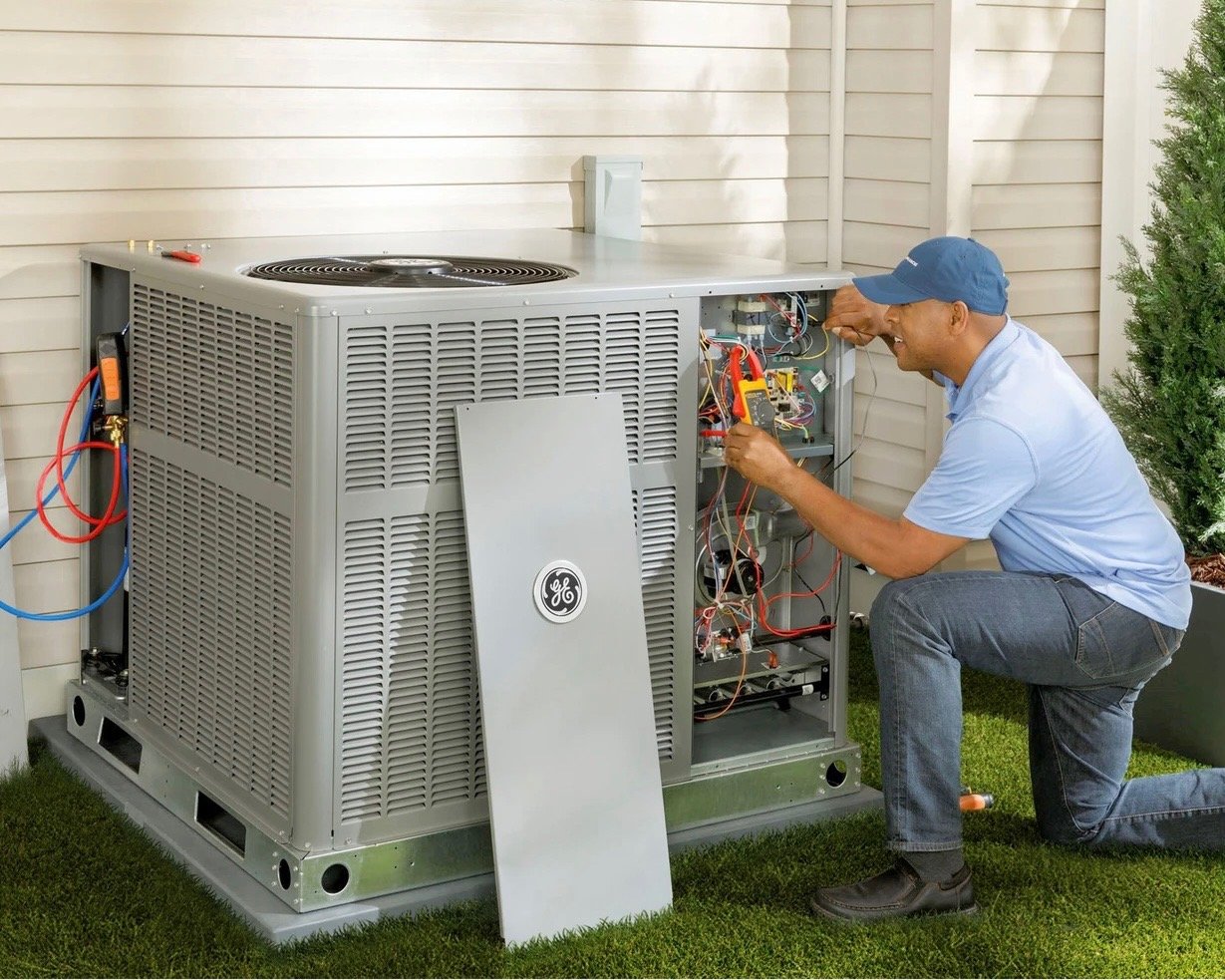 HVAC technician servicing the electrical components of a residential heating and cooling system
